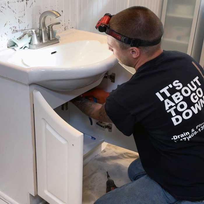 A Local DPS Plumber Fixing A Bathroom Drain Problems Near Arlington Heights A local DPS Plumber near Arlington Heights cleaning a clogged bathroom sink drain